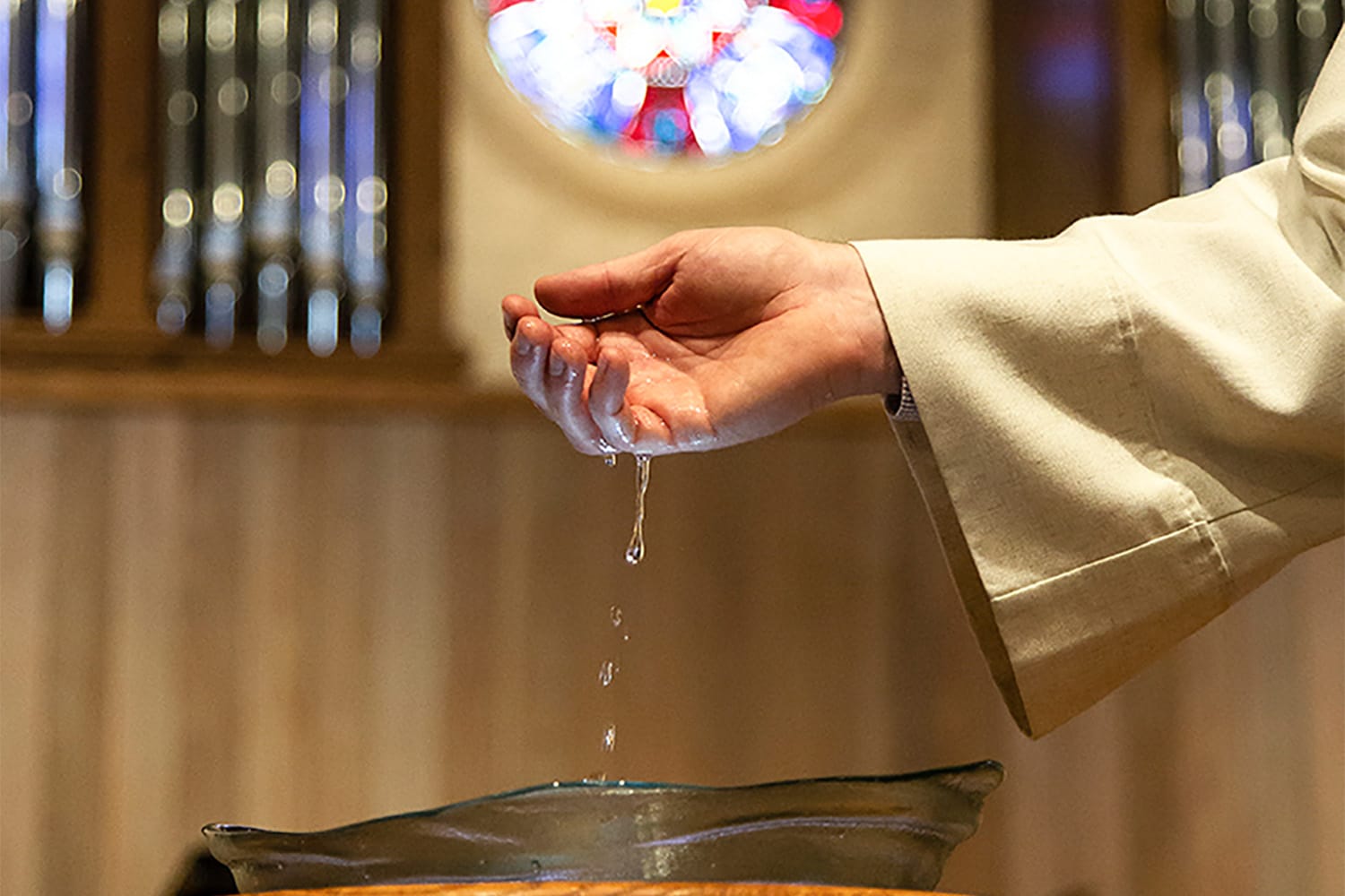 water dripping from pastor's hand